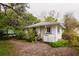 Cozy home exterior with white paint, front entrance stairs and trees providing natural shade and privacy at 3425 E Powhatan Ave, Tampa, FL 33610