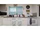 Close up of the kitchen with tile backsplash, decorative cabinet doors and window at 3425 E Powhatan Ave, Tampa, FL 33610