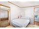 A bedroom with a bed and white walls, featuring an open doorway to another room at 35145 Garber Ln, Zephyrhills, FL 33541