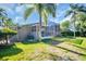 View of the house and screened-in pool area from the lush green backyard at 375 Holly Hill Rd, Oldsmar, FL 34677