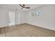 Bedroom features light vinyl floors, a bright window, and an open doorway to an attached bathroom at 375 Holly Hill Rd, Oldsmar, FL 34677