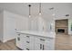 Bright kitchen island with white cabinets and sleek black hardware and an open view of the brick fireplace at 375 Holly Hill Rd, Oldsmar, FL 34677
