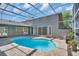 The pool area of the house features a screened enclosure over a kidney shaped pool at 375 Holly Hill Rd, Oldsmar, FL 34677