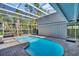 The pool area of the house features a screened enclosure over a kidney shaped pool at 375 Holly Hill Rd, Oldsmar, FL 34677