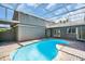 The pool area of the house features a screened enclosure over a kidney shaped pool at 375 Holly Hill Rd, Oldsmar, FL 34677