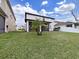 A modern home has a grassy backyard with a young palm tree in the center at 4136 Shrewbury Pl, Land O Lakes, FL 34638