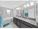 Bright bathroom featuring a double vanity with granite countertop, soaking tub, and glass-enclosed shower at 4136 Shrewbury Pl, Land O Lakes, FL 34638