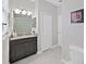 Bathroom featuring dark vanity with granite countertop, tile flooring, and framed artwork at 4136 Shrewbury Pl, Land O Lakes, FL 34638