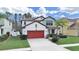 Charming two-story home with well-manicured lawn, beautiful landscaping and a red two car garage door at 4136 Shrewbury Pl, Land O Lakes, FL 34638