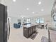 Open layout with island seating, stainless appliances, and a seamless flow to the dining and living areas at 4136 Shrewbury Pl, Land O Lakes, FL 34638