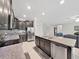 Open kitchen with stainless steel appliances, a center island, and views of the living space with a staircase at 4136 Shrewbury Pl, Land O Lakes, FL 34638