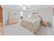 Bright bedroom featuring a large bed, carpeted floor, dresser and a view into the en-suite bathroom at 4136 Shrewbury Pl, Land O Lakes, FL 34638
