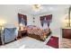 Cozy bedroom with tile floor, windows with curtains, a ceiling fan and a comfortable-looking bed at 4215 Regal Pl, New Port Richey, FL 34652