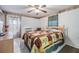 Bedroom featuring a bed with decorative bedding, a ceiling fan, and a sliding glass door at 4215 Regal Pl, New Port Richey, FL 34652
