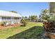 Well-maintained front yard featuring grass, plants, and a small patio with outdoor seating at 4215 Regal Pl, New Port Richey, FL 34652