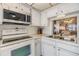 Bright kitchen boasts white appliances, including built-in microwave, and tile backsplash at 4215 Regal Pl, New Port Richey, FL 34652