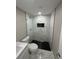 Modern bathroom showcasing a stylish glass-enclosed shower with elegant tile and black honeycomb flooring at 4731 Foothill Dr, Holiday, FL 34690