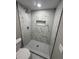Modern shower featuring white marble-style tile and a herringbone patterned floor at 4731 Foothill Dr, Holiday, FL 34690