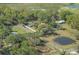 Scenic aerial perspective showcases a quaint residential zone complemented by a serene pond and lush verdant fields at 4814 Knights Loop, Plant City, FL 33565