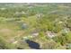 Expansive aerial view revealing a rural landscape with a mix of water bodies, farms, and scattered residential buildings at 4814 Knights Loop, Plant City, FL 33565