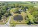 Breathtaking aerial overview featuring a home adjacent to a tranquil pond, beautifully set amidst lush, verdant fields at 4814 Knights Loop, Plant City, FL 33565