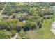 Wide aerial perspective showcases homes nestled amidst lush greenery, adjacent to ponds and sprawling green fields at 4814 Knights Loop, Plant City, FL 33565