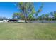 Lush backyard view featuring mature trees, a privacy fence, and an enclosed patio at 4814 Knights Loop, Plant City, FL 33565