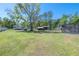 Large, grassy backyard with mature trees and partial views of the home at 4814 Knights Loop, Plant City, FL 33565
