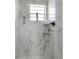Detailed view of a modern bathroom showing white marble tile, shelves and fixtures at 4814 Knights Loop, Plant City, FL 33565