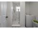 Modern bathroom featuring marble walls, mosaic shower floor, a white washer and a door at 4814 Knights Loop, Plant City, FL 33565