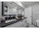 Stylish bathroom boasts a double sink vanity with black countertop, marble look walls, and modern fixtures at 4814 Knights Loop, Plant City, FL 33565