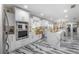 Bright open kitchen with white cabinetry, stainless steel appliances, and designer marble flooring at 4814 Knights Loop, Plant City, FL 33565