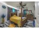 Well-lit main bedroom featuring a four-poster bed, modern ceiling fan, and stylish decor elements at 4814 Knights Loop, Plant City, FL 33565