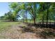 View of the property featuring mature trees, a fence and sunny sky at 4814 Knights Loop, Plant City, FL 33565