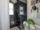 Elegant black tiled shower with a glass partition featuring a modern shower head, and a sleek window at 4814 Knights Loop, Plant City, FL 33565