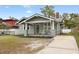 Charming craftsman home featuring a welcoming front porch with rocking chairs and a well-maintained lawn at 5607 N Taliaferro Ave, Tampa, FL 33604