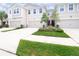 Lovely townhome featuring neutral paint, a two-car garage, and green lawn at 5736 Grand Sonata Ave, Lutz, FL 33558