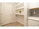 Walk-in pantry with white shelving, counter space, and gray subway tile, adjacent to a white door at 5736 Grand Sonata Ave, Lutz, FL 33558