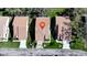 An aerial view of three homes featuring tile roofs, mature landscaping, and well-manicured lawns at 5839 Garden Lakes Dr, Bradenton, FL 34203