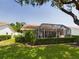 Backyard view of a screened-in lanai, beautiful landscaping, and serene privacy at 5839 Garden Lakes Dr, Bradenton, FL 34203