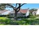 A back yard featuring an enclosed lanai with a tile roof and mature landscaping at 5839 Garden Lakes Dr, Bradenton, FL 34203