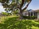 Large tree shading the fenced yard and lanai of the home at 5839 Garden Lakes Dr, Bradenton, FL 34203