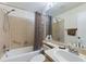 Tiled bathroom featuring a shower-tub combo with updated fixtures and a vanity with sink at 5839 Garden Lakes Dr, Bradenton, FL 34203
