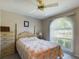 Well-lit bedroom with a large window and a floral-patterned bedspread at 5839 Garden Lakes Dr, Bradenton, FL 34203