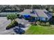 Inviting clubhouse with a blue awning, lush greenery, and ample parking for residents at 5839 Garden Lakes Dr, Bradenton, FL 34203