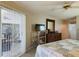 Bright main bedroom featuring a sliding glass door, ceiling fan, dresser, and a flat screen television at 5839 Garden Lakes Dr, Bradenton, FL 34203