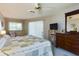 Bright main bedroom featuring a sliding glass door, ceiling fan, dresser, and a flat screen television at 5839 Garden Lakes Dr, Bradenton, FL 34203