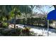 Scenic view of the tennis court is surrounded by lush tropical greenery and mature trees at 5839 Garden Lakes Dr, Bradenton, FL 34203