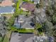 Aerial view of a home featuring a screened-in pool, well-manicured landscaping, and a modern roof at 6107 Ibispark Dr, Lithia, FL 33547