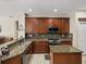 Well-equipped kitchen featuring dark wood cabinets, granite countertops, and stainless steel appliances at 6107 Ibispark Dr, Lithia, FL 33547